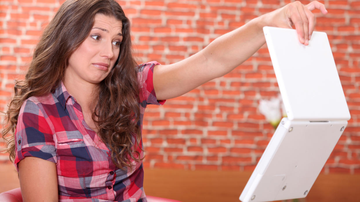  Woman disgusted by her laptop. 