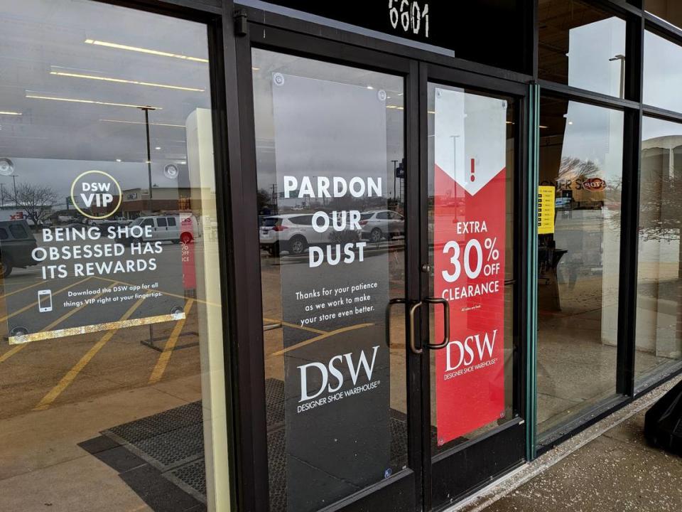 Door signage at DSW lets customers know about the current construction work inside. The store is downsizing to accommodate two new stores next door. Jennifer Green/jgreen@bnd.com
