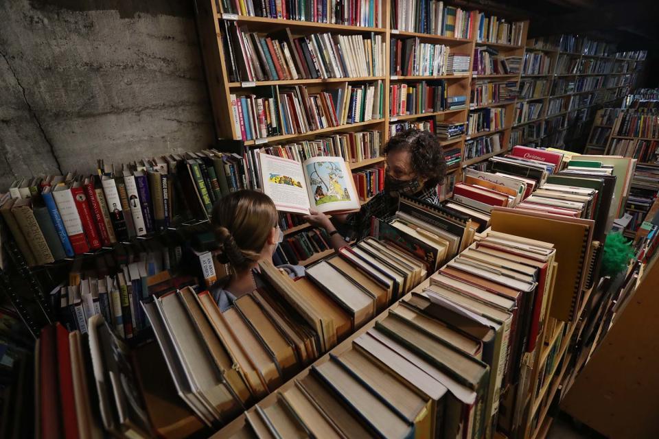 Owner Linda Snowball, right, helps a customer in the "super secret basement" of Snowball Bookshop in downtown Barberton.  The store is one of the largest used and out-of-print bookstores in Northeast Ohio.