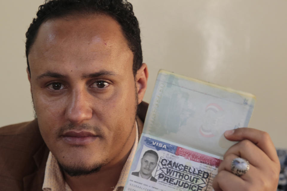 Mohammed Al Zabidi holds his canceled U.S. visa at his home in Sanaa, Yemen, on Thursday, Jan. 28, 2021. The Trump administration’s travel ban that affected several Muslim-majority nations robbed him of his American dream and his chance to escape his war-torn homeland. With a new president at the helm, the ban is over, but Al Zabidi’s plight isn’t. (AP Photo/Hani Mohammed)