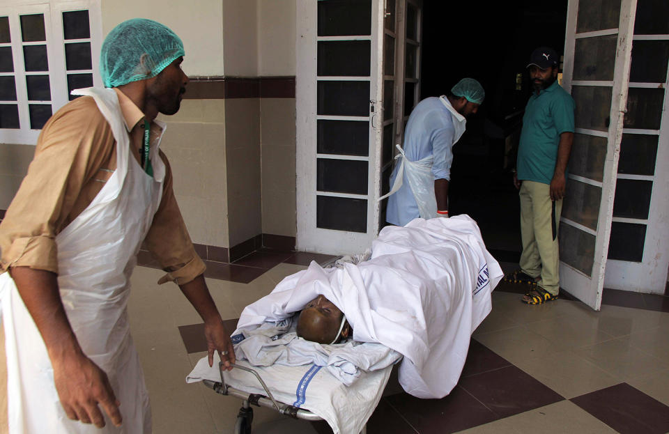 <p>Pakistani hospital staff transport a victim of an oil tanker explosion at a hospital in Multan, Pakistan, Sunday, June 25, 2017. An overturned oil tanker burst into flames in Pakistan on Sunday, killing scores of people who had rushed to the scene of the highway accident to gather leaking fuel, an official said. (AP Photo/Adeel Khan) </p>