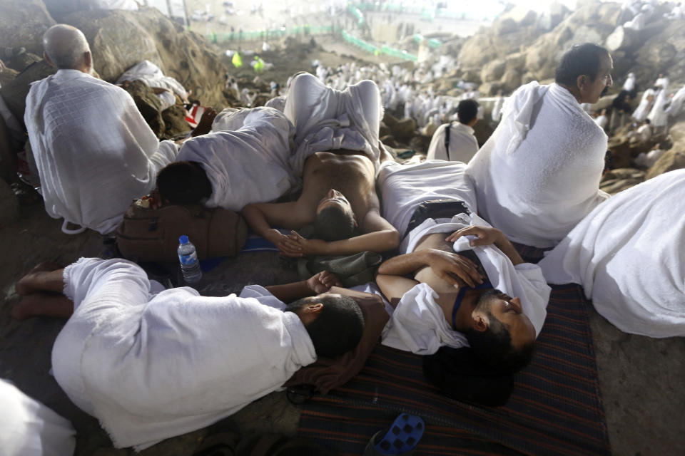 Muslim pilgrims take a nap on a rocky hill known as Mountain of Mercy, on the Plain of Arafat, during the annual hajj pilgrimage, ahead of sunrise near the holy city of Mecca, Saudi Arabia, Saturday, Aug. 10, 2019. More than 2 million pilgrims were gathered to perform initial rites of the hajj, an Islamic pilgrimage that takes the faithful along a path traversed by the Prophet Muhammad some 1,400 years ago. (AP Photo/Amr Nabil)