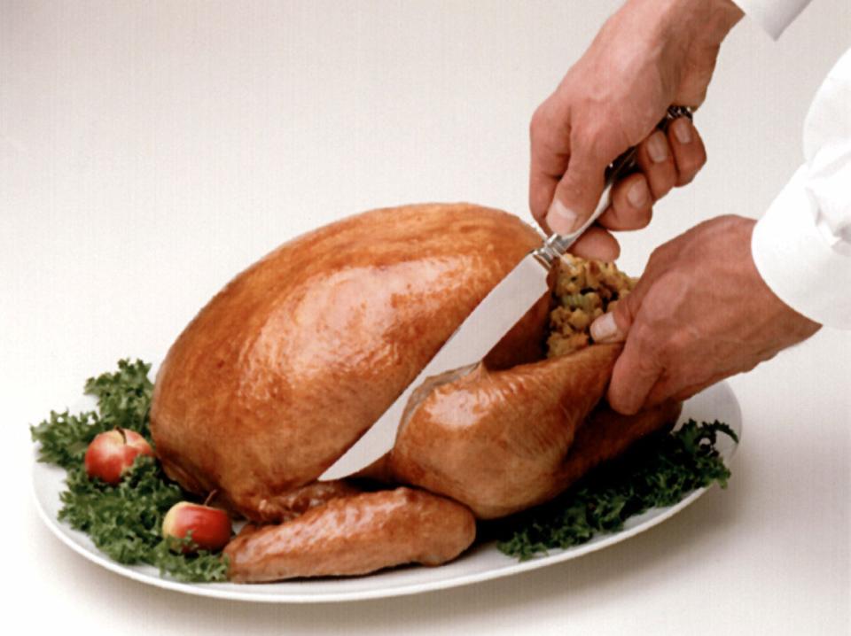 Carving the Thanksgiving turkey: Step 1: Cut band of skin holding drumsticks. Grasp end of drumstick. Place knife between drumstick/thigh and body of the turkey and cut through skin to joint. Remove entire leg by pulling out and back, using the point of the knife to disjoin it at the joint. BUTTERBALL