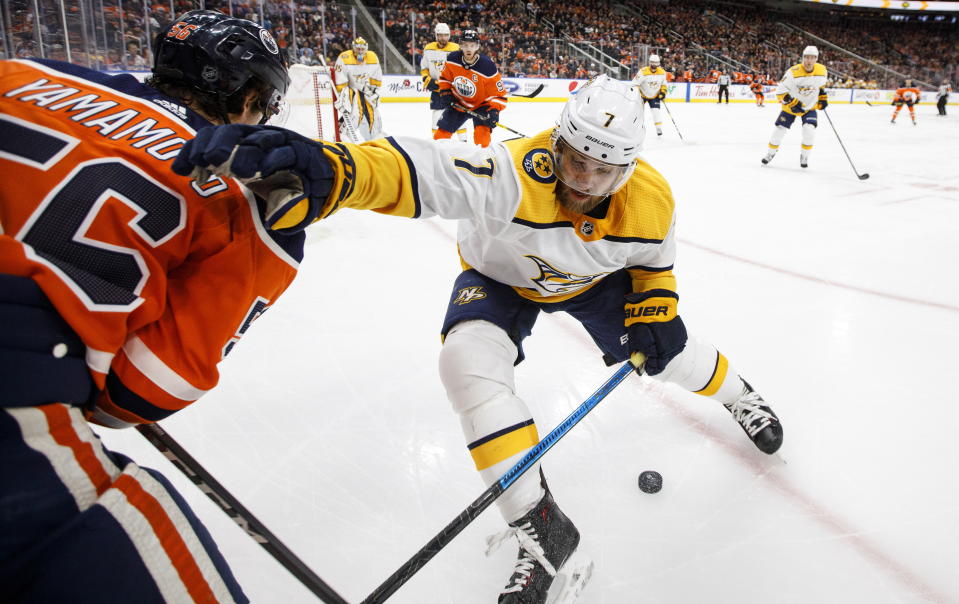 Nashville Predators' Yannick Weber (7) and Edmonton Oilers' Kailer Yamamoto (56) battle for the puck during second period NHL hockey action in Edmonton, Alberta, Tuesday, Jan. 14, 2019. (Jason Franson/The Canadian Press via AP)