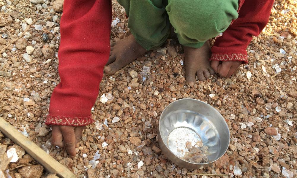 A girl collects mica flakes from an open-cast illegal mica mine in the eastern state of Jharkhand, India