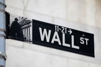 FILE PHOTO: A street sign for Wall Street is seen outside of the New York Stock Exchange (NYSE) in New York City