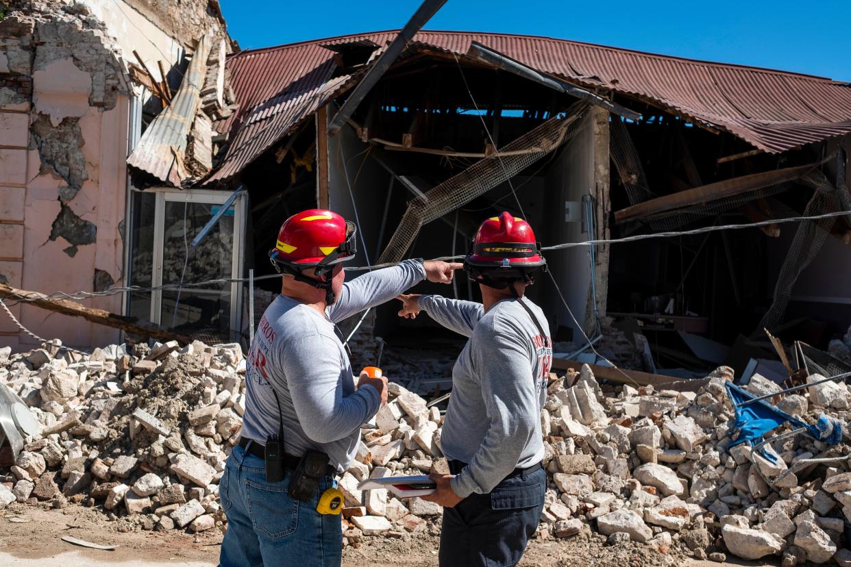 Two firemen survey a collapsed building after an earthquake hit the island in Guanica, Puerto Rico on January 7, 2020. - A strong earthquake struck south of Puerto Rico early January 7, 2020 followed by major aftershocks, the US Geological Survey said, the latest in a series of tremors that have shaken the island since December 28.