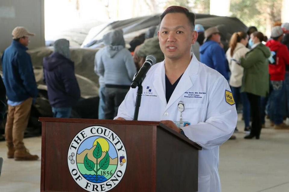 UCSF Fresno medical director Dr. Kenny Banh praises the Feb. 14, 2023 launch of the Fresno County Rural Mobile Health Program. while Terranova Ranch workers line up for exams and flu shots.