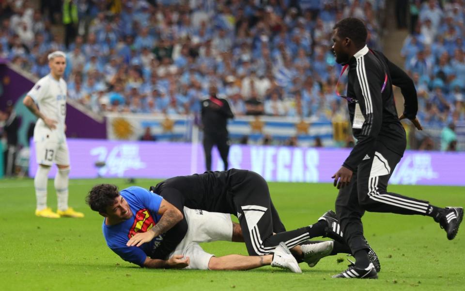 A protester on the pitch with rainbow flag and frre ukraine t shirt during the FIFA World Cup Qatar 2022 Group H match between Portugal and Uruguay at Lusail Stadium on November 28, 2022 in Lusail City, Qatar - Marc Atkins/Getty Images