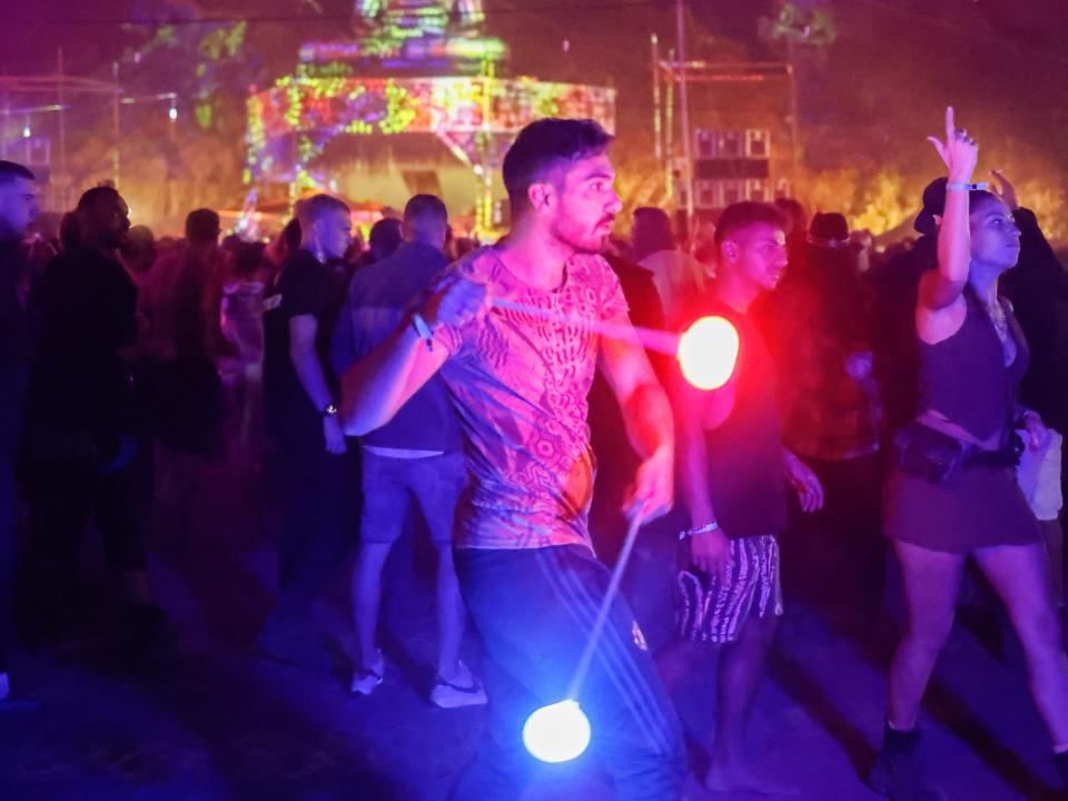 festival-goer twirling light-up stick in crowd