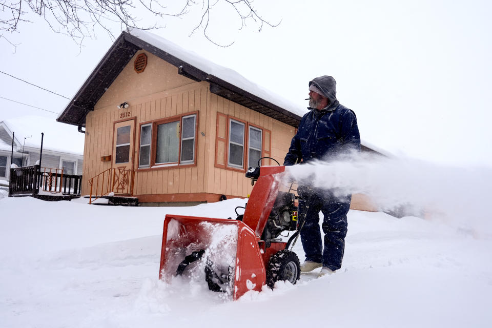 Ron Cook uses a snow blower to clear snow from his driveway in Sioux City, Iowa, Friday, Jan. 12, 2024. (AP Photo/Carolyn Kaster)