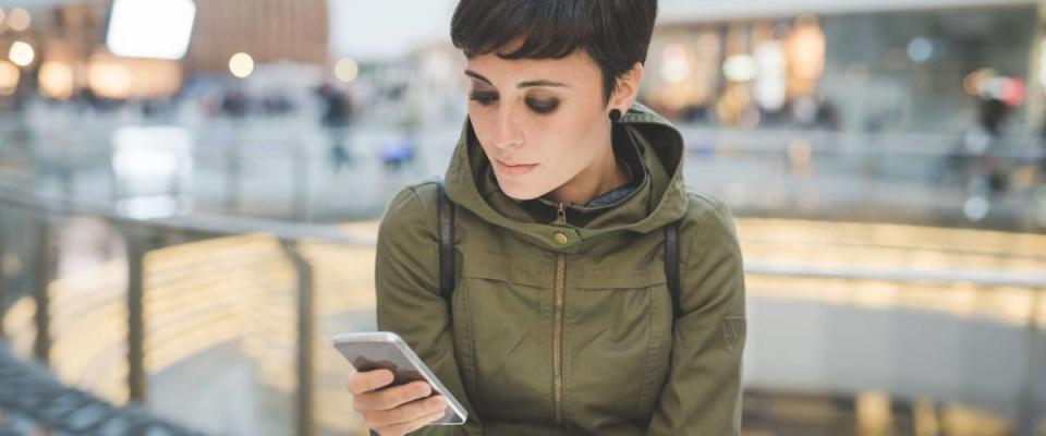 Half length of young handsome caucasian brown straight hair woman using smartphone and tablet, looking downward screen, smiling - multitasking, technology, social network concept concept