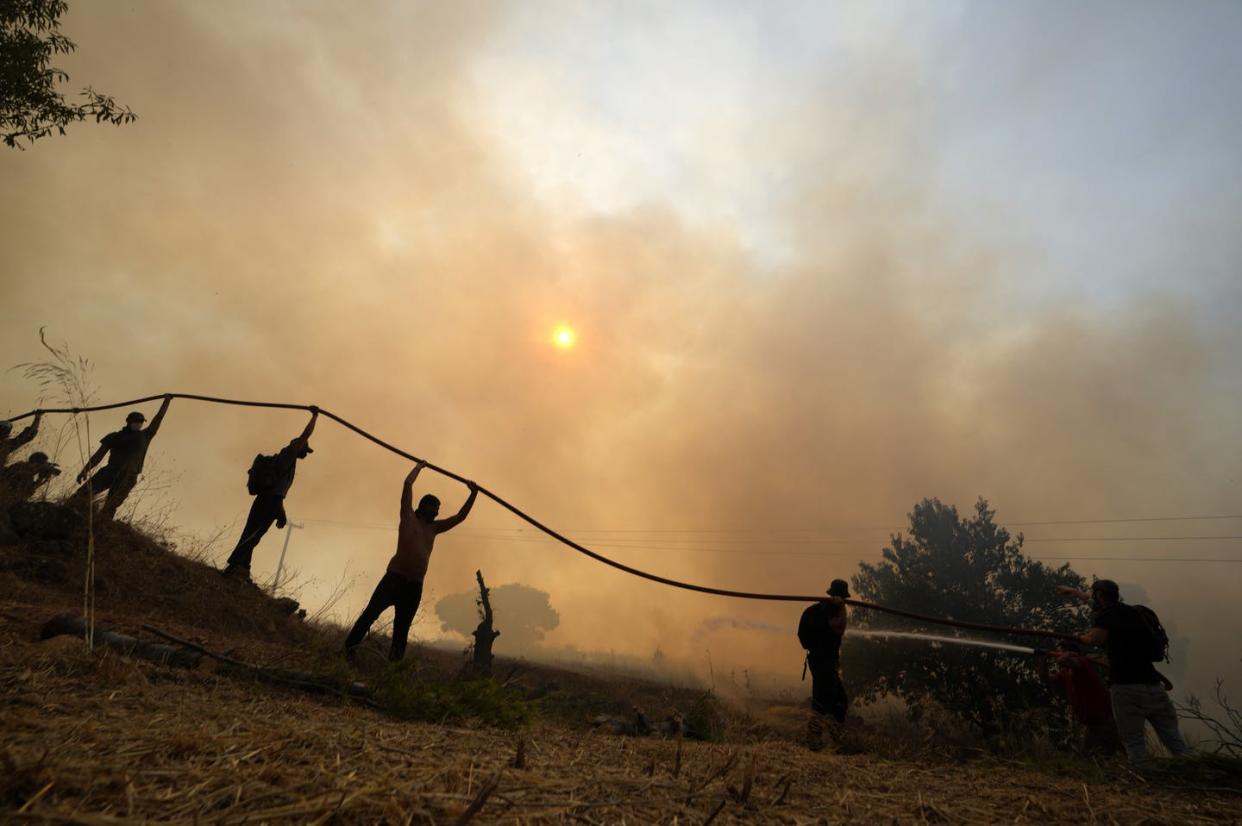 <span class="caption">Firefighters and residents battle a blaze in hot, dry conditions in Athens, Greece, in August 2021.</span> <span class="attribution"><a class="link " href="https://newsroom.ap.org/detail/EuropeandAfricaPicturesoftheWeekPhotoGallery/96d8941b2a7c4091ab1e0fcb4346aa7e/photo" rel="nofollow noopener" target="_blank" data-ylk="slk:AP Photo/Petros Karadjias;elm:context_link;itc:0;sec:content-canvas">AP Photo/Petros Karadjias</a></span>