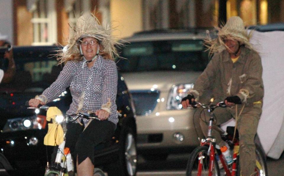 Deon Schneider and Nick Schneider of O’Fallon, Missouri, ride in scarecrow costumes.