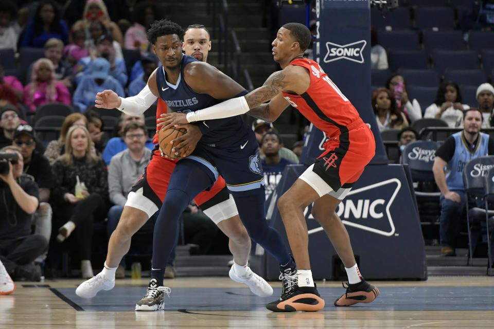 Memphis Grizzlies forward Jaren Jackson Jr. protect the ball from Houston Rockets forward Jabari Smith Jr., right, as forward Dillon Brooks defends during the first half of an NBA basketball game Wednesday, Feb. 14, 2024, in Memphis, Tenn. (AP Photo/Brandon Dill)