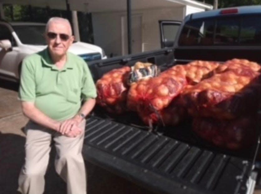 Columbia Civitan Club member Hueston Marshall sits with bags of Vidalia onions ready for distribution.