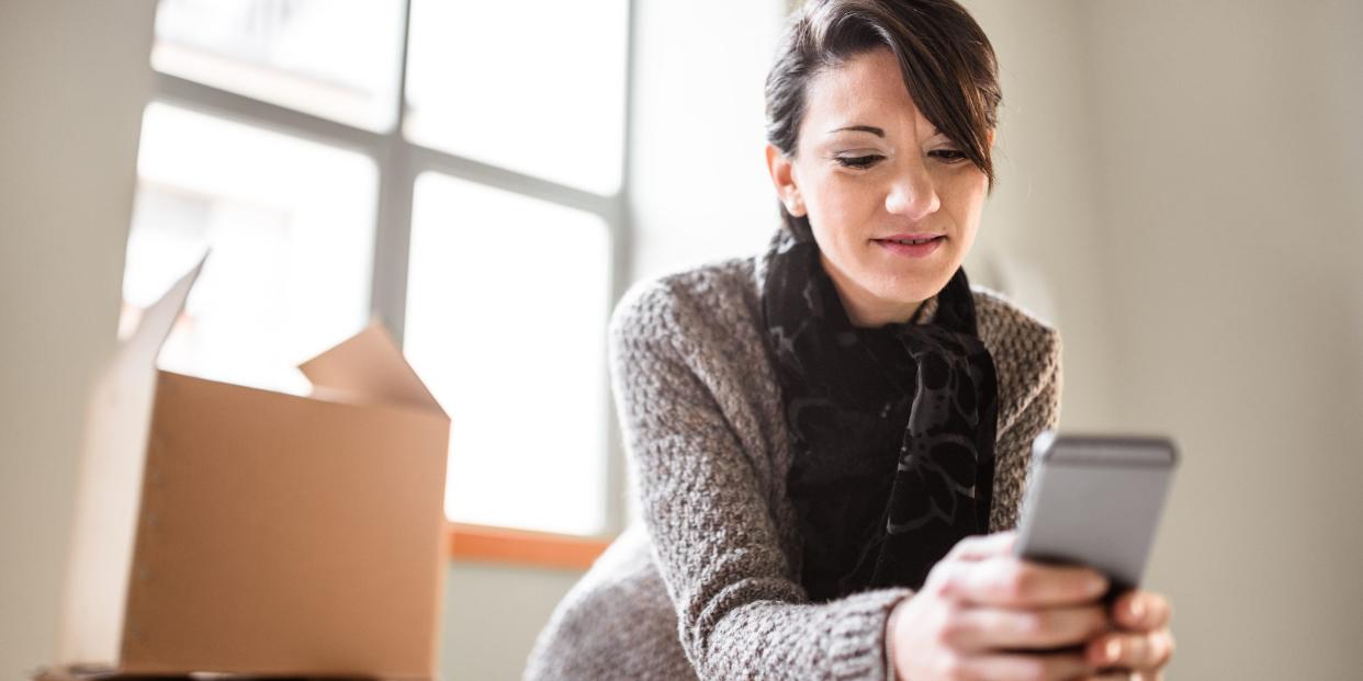 woman holding phone with packages tracking