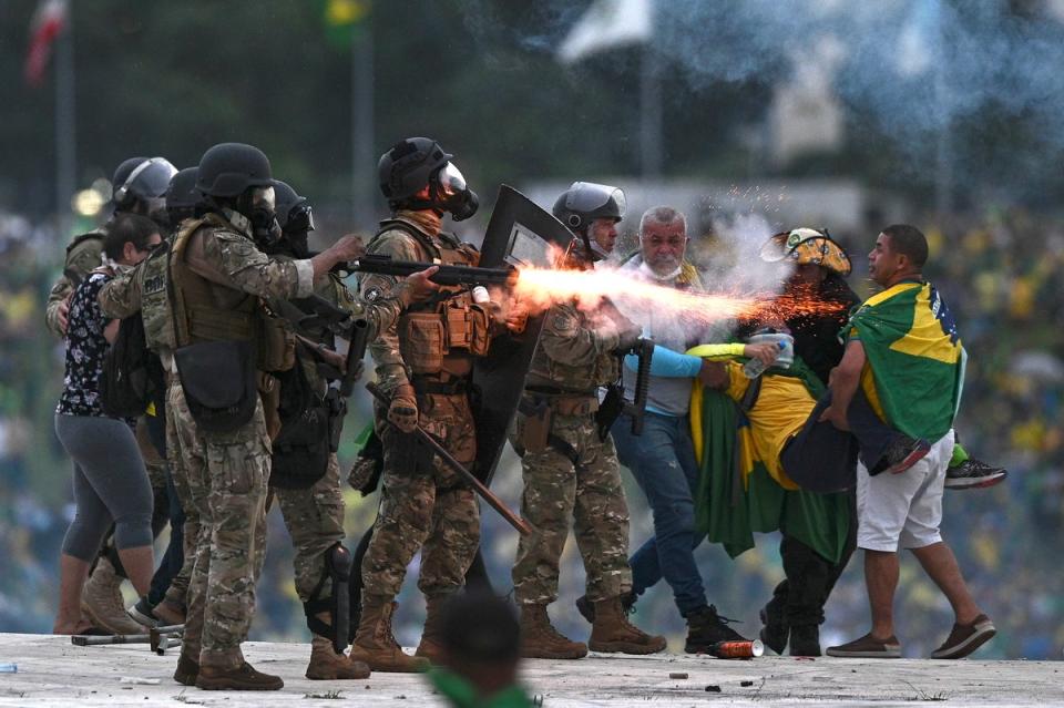 Police confront Bolsonaro supporters during the clashes (EPA)