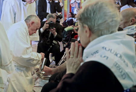 Pope Francis kisses a foot of a disabled person at the S. Maria della Provvidenza church in Rome, during a Holy Thursday celebration, in this April 17, 2014 file photo. REUTERS/Tony Gentile/Files