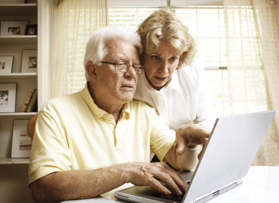 A senior couple using their laptop to check something online.