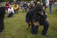 Members of the Proud Boys and other right-wing demonstrators kneel in prayer at rally on Saturday, Sept. 26, 2020, in Portland, Ore. (AP Photo/Allison Dinner)