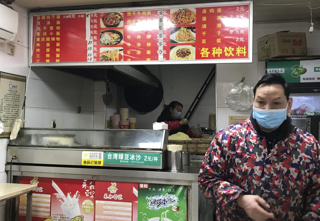 Stores owners of a store selling a local favorite "reganmian," or "hot dry noodles," prepare takeaway orders in Wuhan in central China's Hubei province on Tuesday, March 31, 2020. The reappearance of Wuhan's favorite noodles is a tasty sign that life is slowly returning to normal in the Chinese city at the epicenter of the global coronavirus outbreak. The steady stream of customers buying bags of noodles smothered in peanut sauce testifies to a powerful desire to enjoy the familiar again after months of strict lockdown.