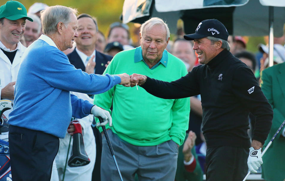 Arnold Palmer, center, watches as Jack Nicklaus, left, and Gary Player touch fists after Palmer hit his ceremonial drive on the first tee during the first round of the Masters golf tournament Thursday, April 10, 2014, in Augusta, Ga. (AP Photo/Atlanta Journal-Constitution, Curtis Compton) MARIETTA DAILY OUT; GWINNETT DAILY POST OUT; LOCAL TV OUT; WXIA-TV OUT; WGCL-TV OUT