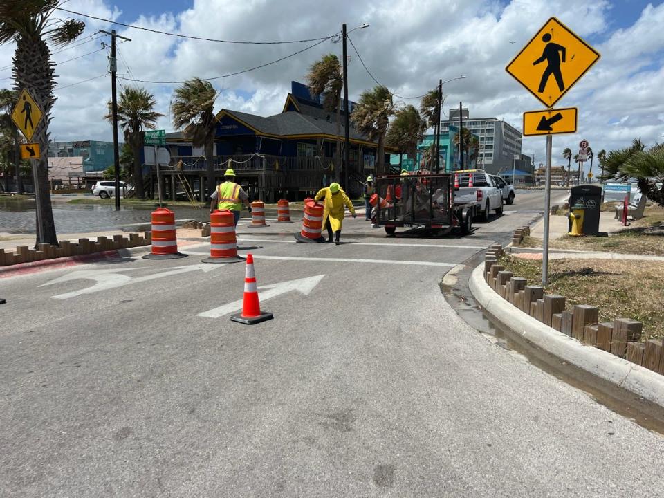 In this photo contributed by the city of Corpus Christi, road crews set up orange traffic barrels along areas of North Beach experiencing the beginnings of storm surge Tuesday afternoon.