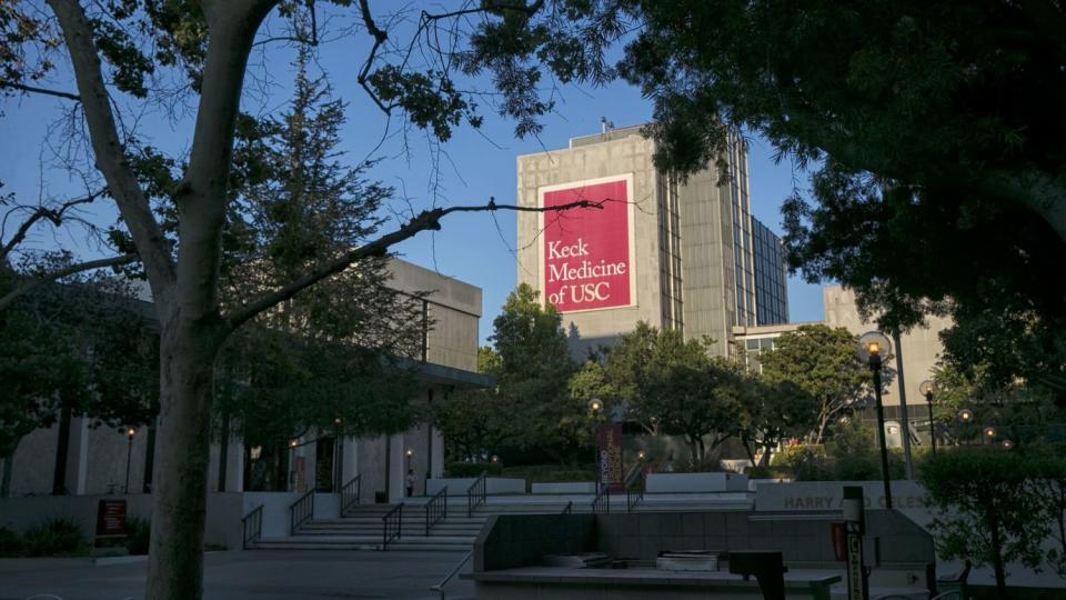 On the Kick School of Medicine campus, the sun shines on the side of a building that bears the sign "Keck Medicine of USC."