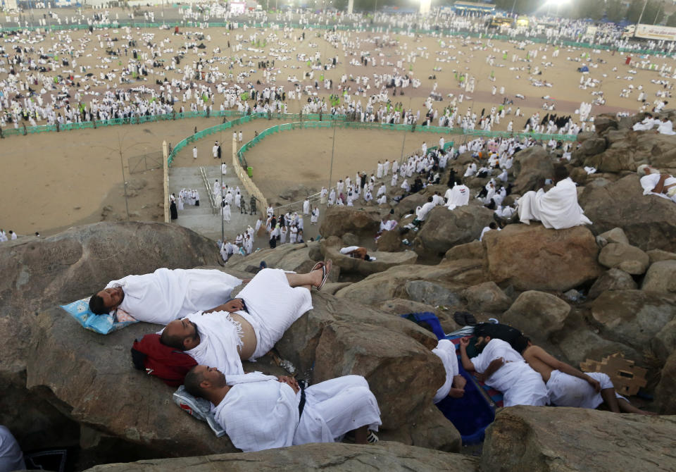 Muslim pilgrims take a nap on a rocky hill known as Mountain of Mercy, on the Plain of Arafat, during the annual hajj pilgrimage, ahead of sunrise near the holy city of Mecca, Saudi Arabia, Saturday, Aug. 10, 2019. More than 2 million pilgrims were gathered to perform initial rites of the hajj, an Islamic pilgrimage that takes the faithful along a path traversed by the Prophet Muhammad some 1,400 years ago. (AP Photo/Amr Nabil)