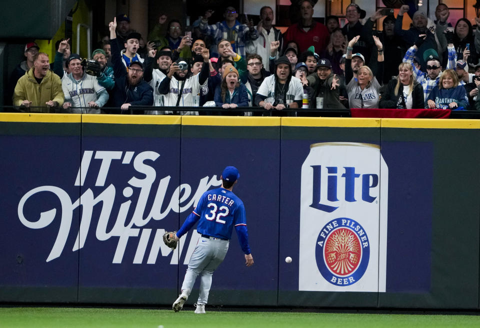 Texas Rangers left fielder Evan Carter watches the game-winning, two-run double by Seattle Mariners' J.P. Crawford, as fans cheer during the ninth inning of a baseball game Thursday, Sept. 28, 2023, in Seattle. (AP Photo/Lindsey Wasson)