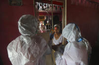 Health workers screen people for COVID-19 symptoms at a residential building in Dharavi , one of Asia's biggest slums, in Mumbai, India, Friday, Aug. 7, 2020. As India hit another grim milestone in the coronavirus pandemic on Friday, crossing 2 million cases and more than 41,000 deaths, community health volunteers went on strike complaining they were ill-equipped to respond to the wave of infection in rural areas. (AP Photo/Rafiq Maqbool)