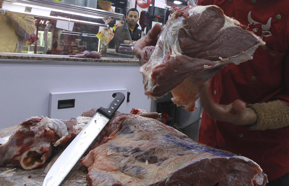 Workers prepare meat to be sold to customers in a butchery in Algiers, Algeria, Sunday, Feb. 18, 2024. Algeria is importing massive amounts of beef and lamb to confront an explosion in demand for meat expected throughout the Muslim holy month of Ramadan, hoping to stabilize prices as the country's economy continues to struggle. The oil-rich North African nation is among countries working to import food and fuel, hoping to meet the requirements of Algerians preparing nightly feasts as their families break their sunrise-to-sunset fasts. (AP Photo/Fateh Guidoum)