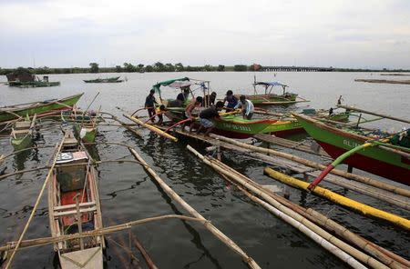 Residents secures their small boat in a safer area in preparations for the strong winds brought by Typhoon Rammasun, locally name Glenda, in a coastal area of Cavite city, south of Manila July 15, 2014. REUTERS/Romeo Ranoco