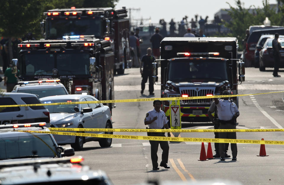 Investigators and emergency personnel gather adjacent to Eugene Simpson Field.