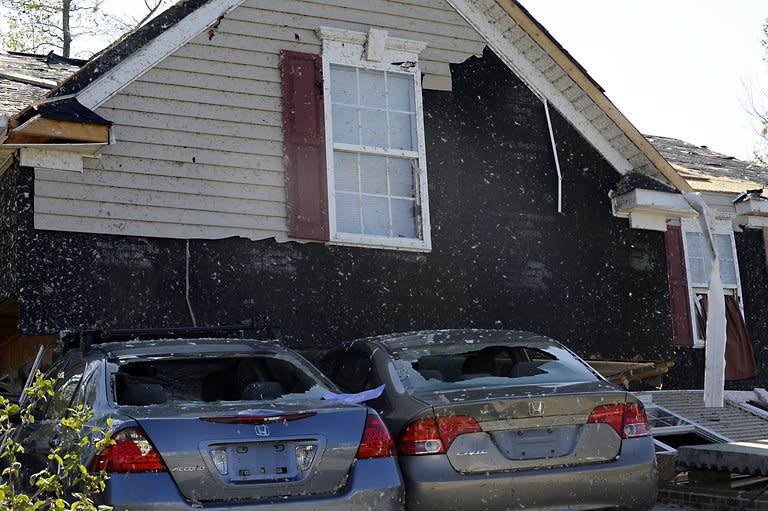 A home sits on top of cars in Raleigh, North Carolina. The worst tornadoes to hit parts of the United States in decades have left 44 people dead, stripping roofs off houses and tossing mobile homes into the air like toys, emergency officials said Sunday