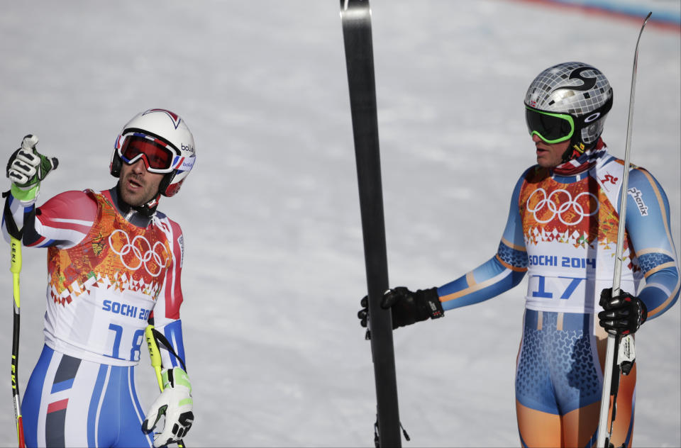 France's Adrien Theaux, left, and Norway's Aksel Lund Svindal talk in the finish area after a men's downhill training run for the 2014 Winter Olympics, Thursday, Feb. 6, 2014, in Krasnaya Polyana, Russia. (AP Photo/Gero Breloer)