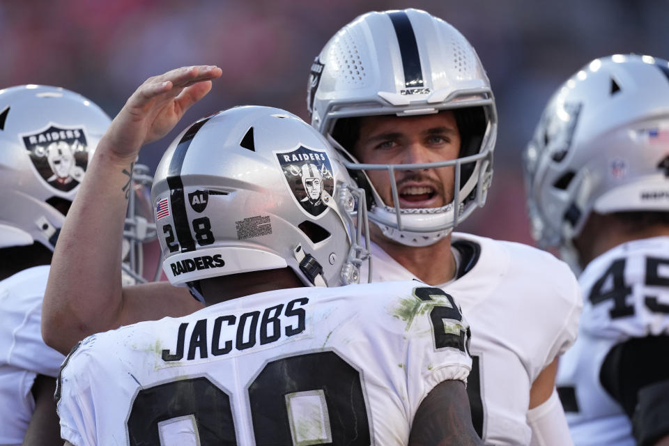 Las Vegas Raiders running back Josh Jacobs (28) celebrates his touchdown with quarterback Derek Carr during the second half of an NFL football game against theDenver Broncos, Sunday, Oct. 17, 2021, in Denver. (AP Photo/David Zalubowski)