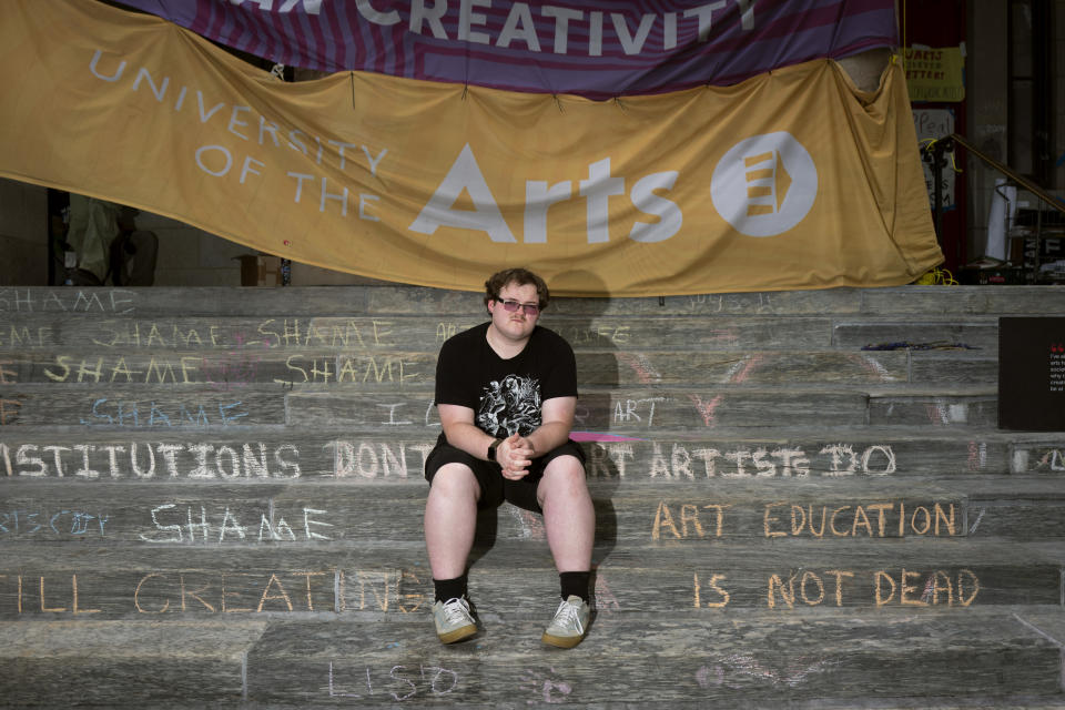 Rising sophomore Ian Callaghan-Kenna, 19, sits on the steps of Dorrance Hamilton Hall at the University of the Arts, Friday, June 14, 2024, in Philadelphia. Students at the university were thrown into panic mode two weeks ago, as they got the startling news that their school would be shutting down within days. Callaghan-Kenna, a film major, who commuted by bus to the university, has been coping with bouts of intense anxiety — not least because the college already has thousands of dollars of his federal aid for the fall term. He has joined a potential class-action lawsuit against the school. (AP Photo/Joe Lamberti)