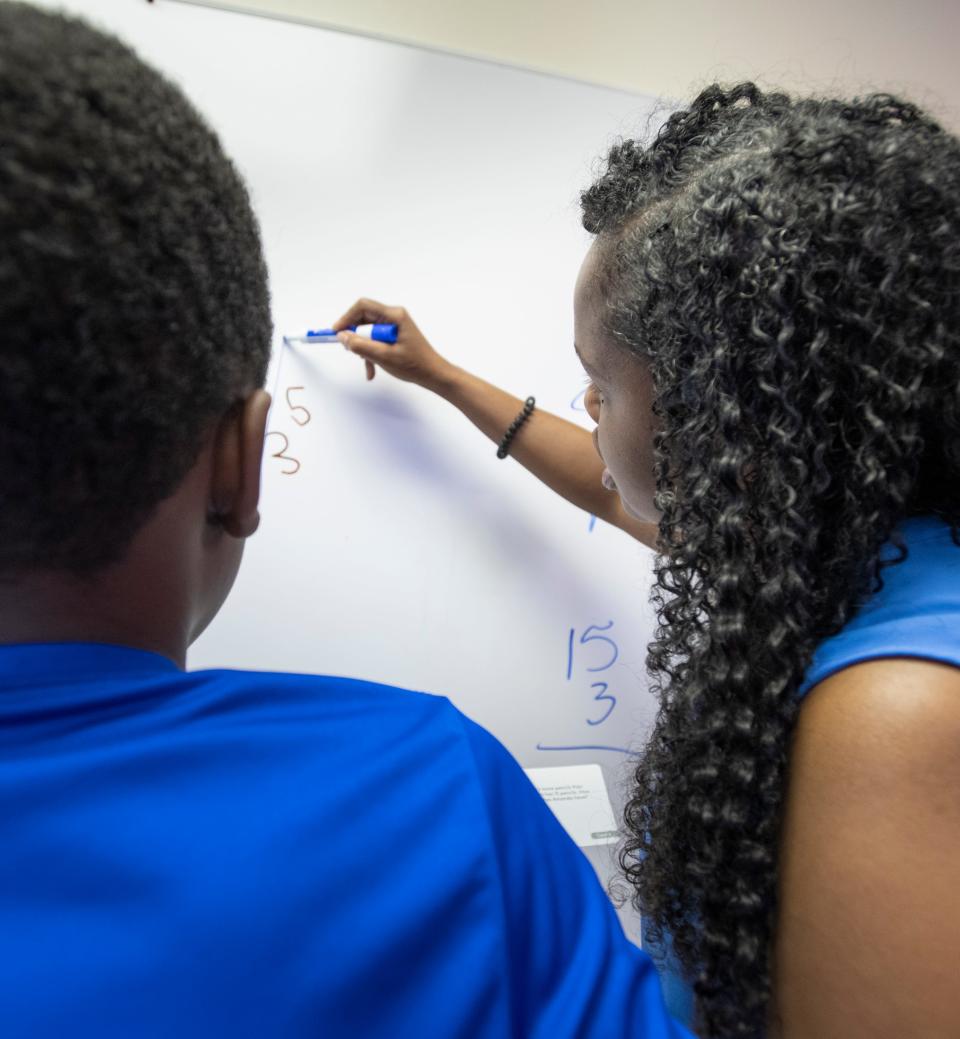 Kenita Mitchell helps a child with a math problem at Harmonic Learning Education and Training in Pensacola on Thursday. The center was awarded a $1,500 grant from Bantucola to expand.