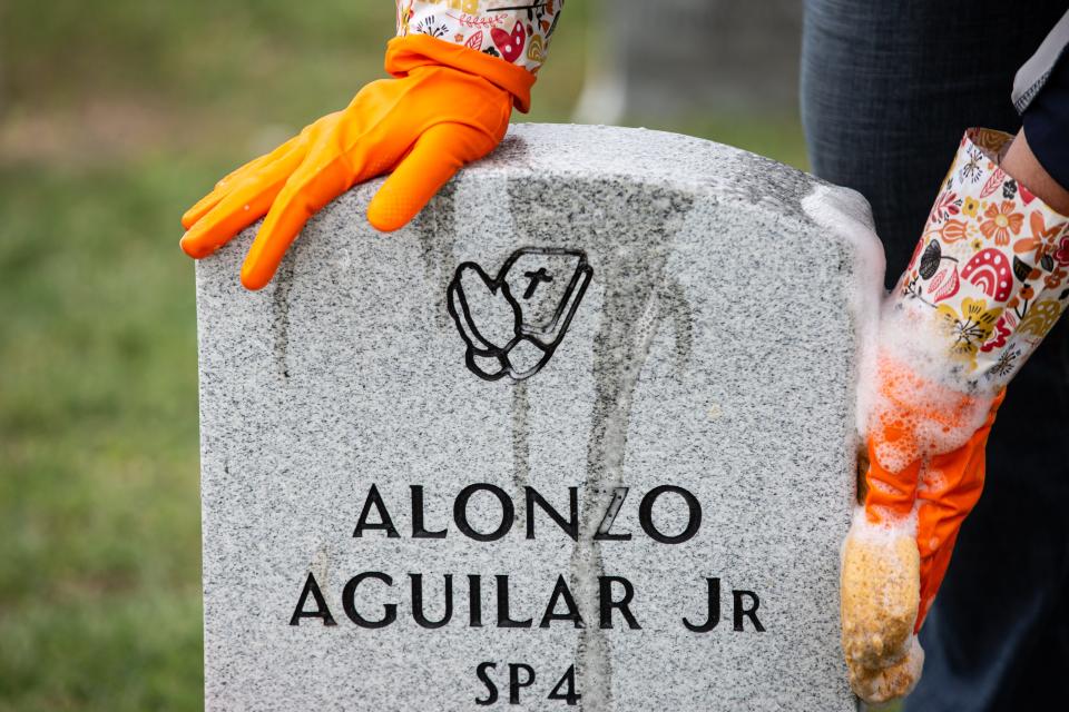 Volunteer with TAMUCC, Rebecca Williamson wipes down a headstone with soapy water at the Coastal Bend Veteran's Cemetery on Tuesday, Nov. 28, 2023, in Corpus Christi, Texas.