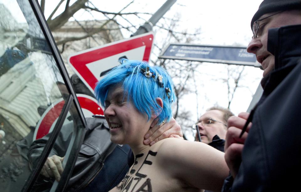 An activist is arrested a protest by her and others against Russia's anti-gay laws ahead of the opening of the Olympic Games in Sochi, in front of the Russian Embassy in Berlin, Germany, Friday, Feb. 7, 2014. (AP Photo/Axel Schmidt)