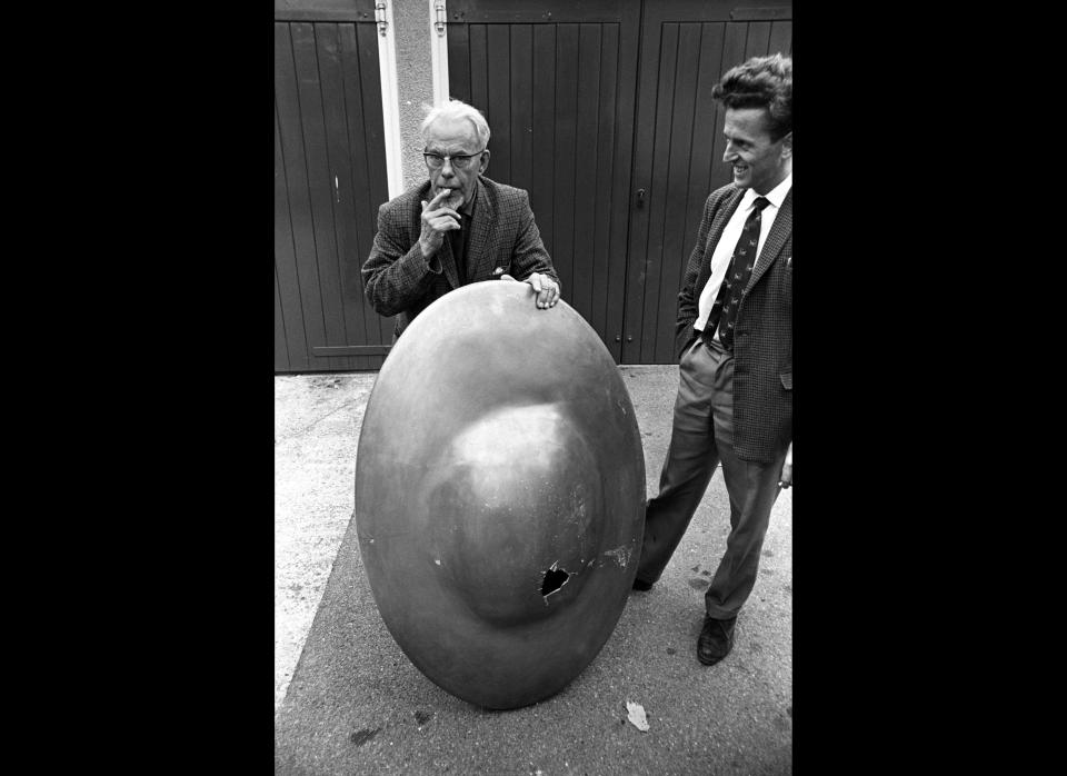 Engineer Michael J Willcocks applies the taste test to the liquid found in the mystery object found at Clevedon, Somerset, by a schoolboy. The liquid was later identified as pig swill. The object was one of five strange objects, all resembling flying saucers and emitting noises, found in different parts of the country. (Photo credit: PA)