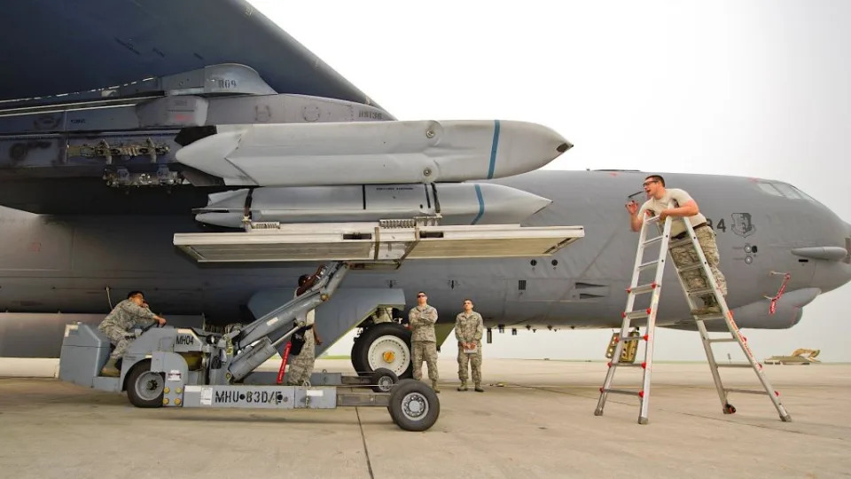 Air Force personnel load AGM-158 JASSM-series cruise missiles onto pylons under the wing of a B-52.<em> U.S. Air Force</em><br> www.twz.com