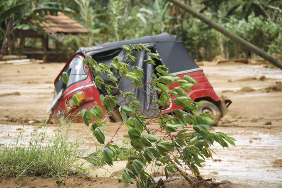 A three-wheel auto-rickshaw partly submerged in mud after a massive landslide at Aranayaka in Kegalle District, about 45 miles north of Colombo, Sri Lanka, May 18, 2016. (Sri Lanka Red Cross via AP)