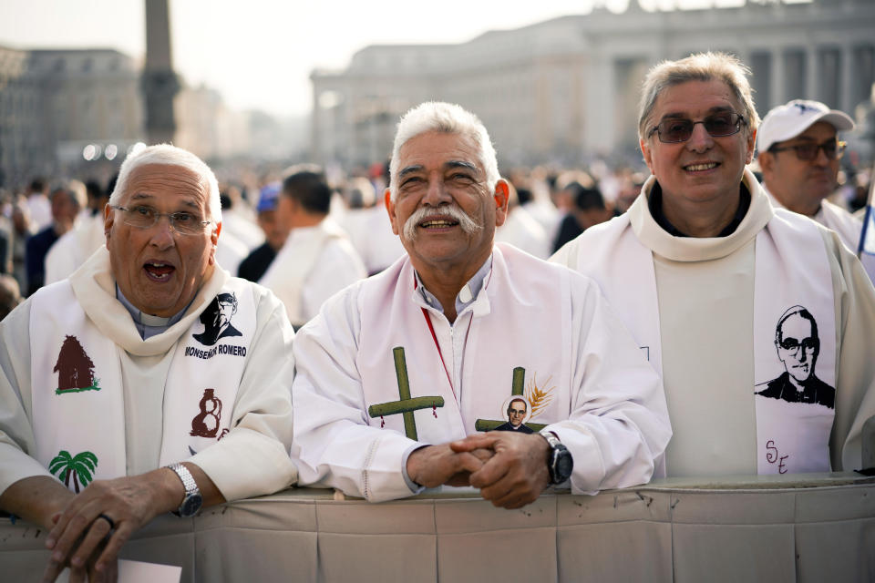 Priests wearing vestments with the effigy of martyred Salvadoran Archbishop Oscar Romero attend a canonization ceremony in St. Peter's Square at the Vatican, Sunday, Oct. 14, 2018. Pope Francis canonizes two of the most important and contested figures of the 20th-century Catholic Church, declaring Pope Paul VI and the martyred Salvadoran Archbishop Oscar Romero as models of saintliness for the faithful today. (AP Photo/Andrew Medichini)