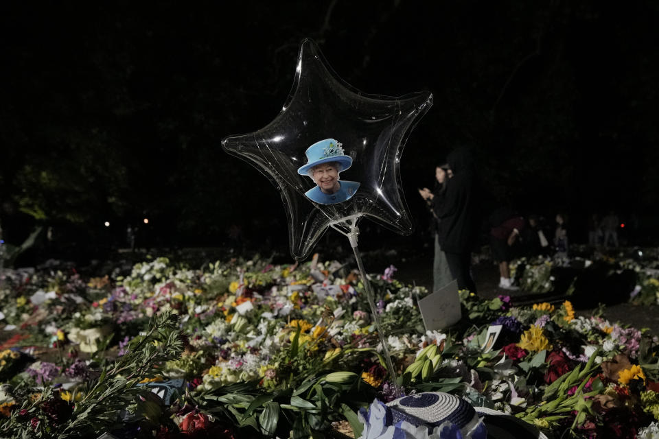 A photograph of Queen Elizabeth II is placed inside a balloon as people bring floral tributes in London's Green Park, Monday, Sept. 12, 2022. Queen Elizabeth II, Britain's longest-reigning monarch and a rock of stability across much of a turbulent century, died Thursday Sept. 8, 2022, after 70 years on the throne, at the age of 96. (AP Photo/Andreea Alexandru)