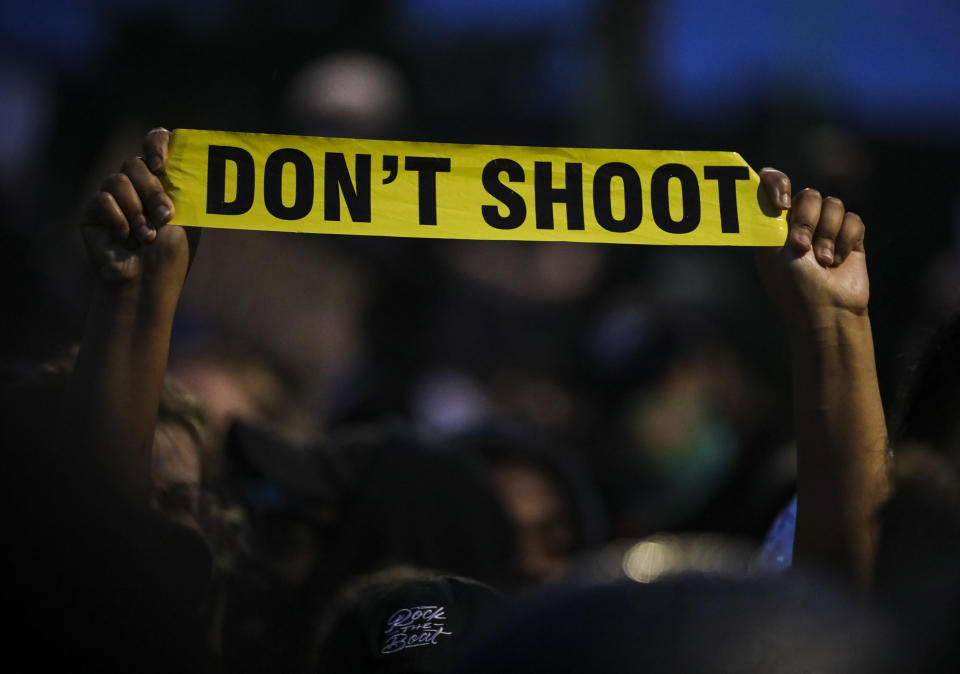 <i>A protester holds up a piece of yellow plastic that reads, "Don't shoot" while participating in a demonstration outside the Forest Hills MBTA Station in Boston on June 2.</i>