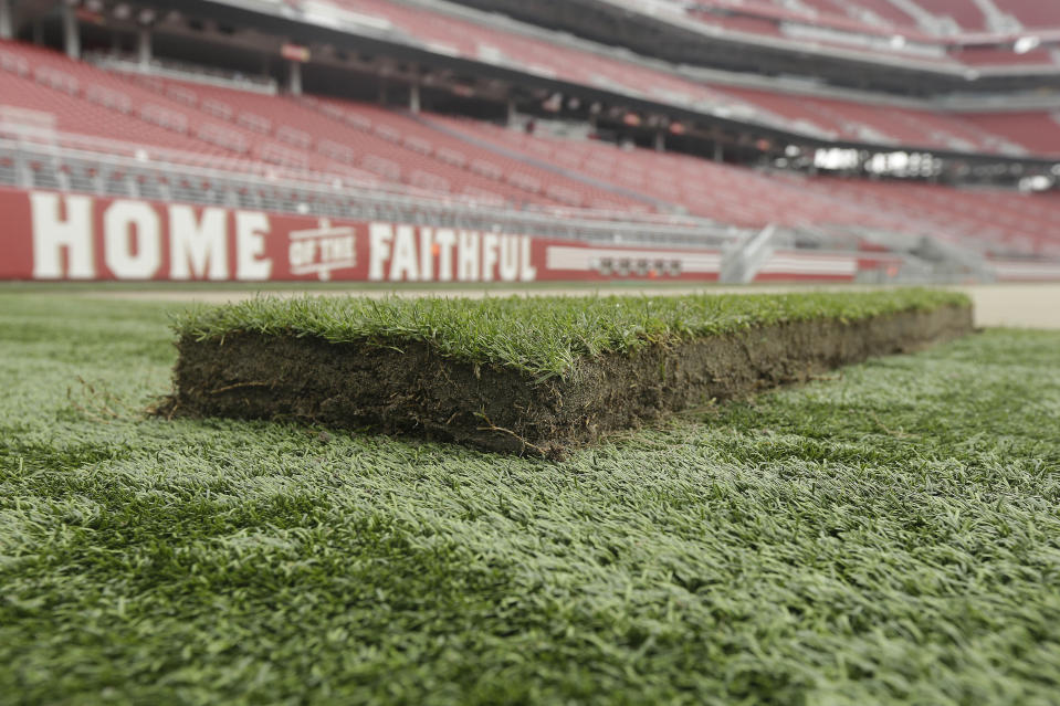 FILE - A piece of sod is shown on the field as workers prepare the field for the NFL's Super Bowl 50 at Levi's Stadium in Santa Clara, Calif., Jan. 11, 2016. When Aaron Rodgers went down with an injury just a few plays into his first season with the New York Jets, it reignited calls from NFL players to have all the stadiums in which they play use natural grass fields for their safety. In major college football, the players don’t have a union behind them to voice concerns. (AP Photo/Jeff Chiu, File)