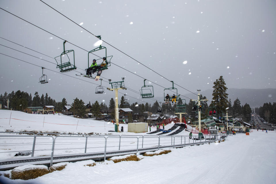 In this photo provided by Big Bear Mountain Resort, snowboard and ski enthusiasts ride a lift to the slopes at Big Bear Mountain Resort in Big Bear, Calif., Monday, Dec. 23, 2019. Winter weather advisories are in effect for the interior mountains of Los Angeles and Ventura counties, where a foot more of snow is expected at elevations above 7,000 feet and lesser amounts down to 5,000 feet. (Jared Meyer/Big Bear Mountain Resort via AP)